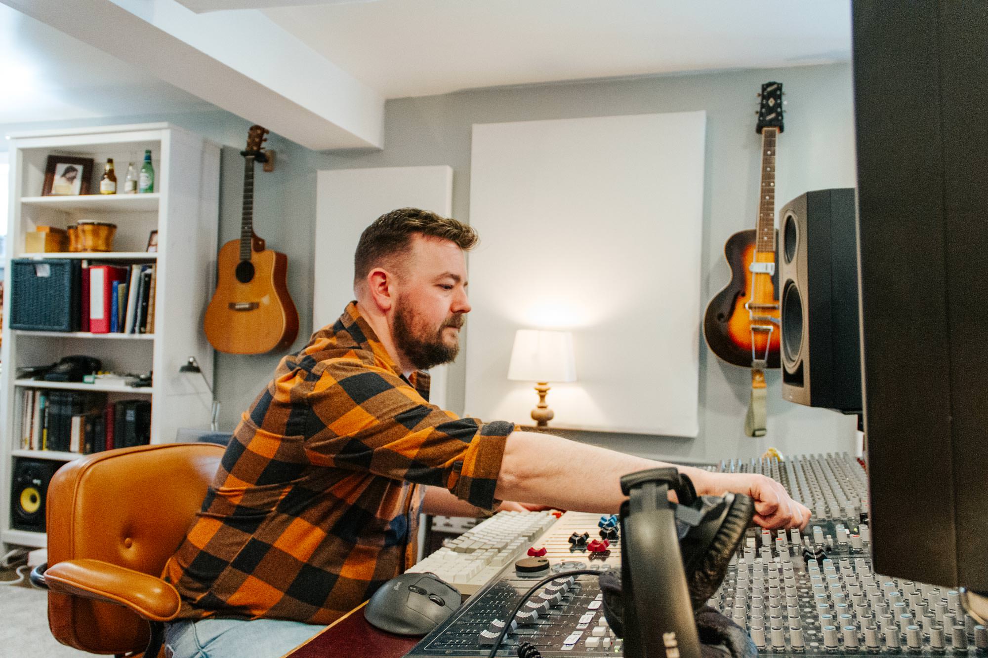 Ben adjusting at the mixing console in Shattered Glass Records Studio.